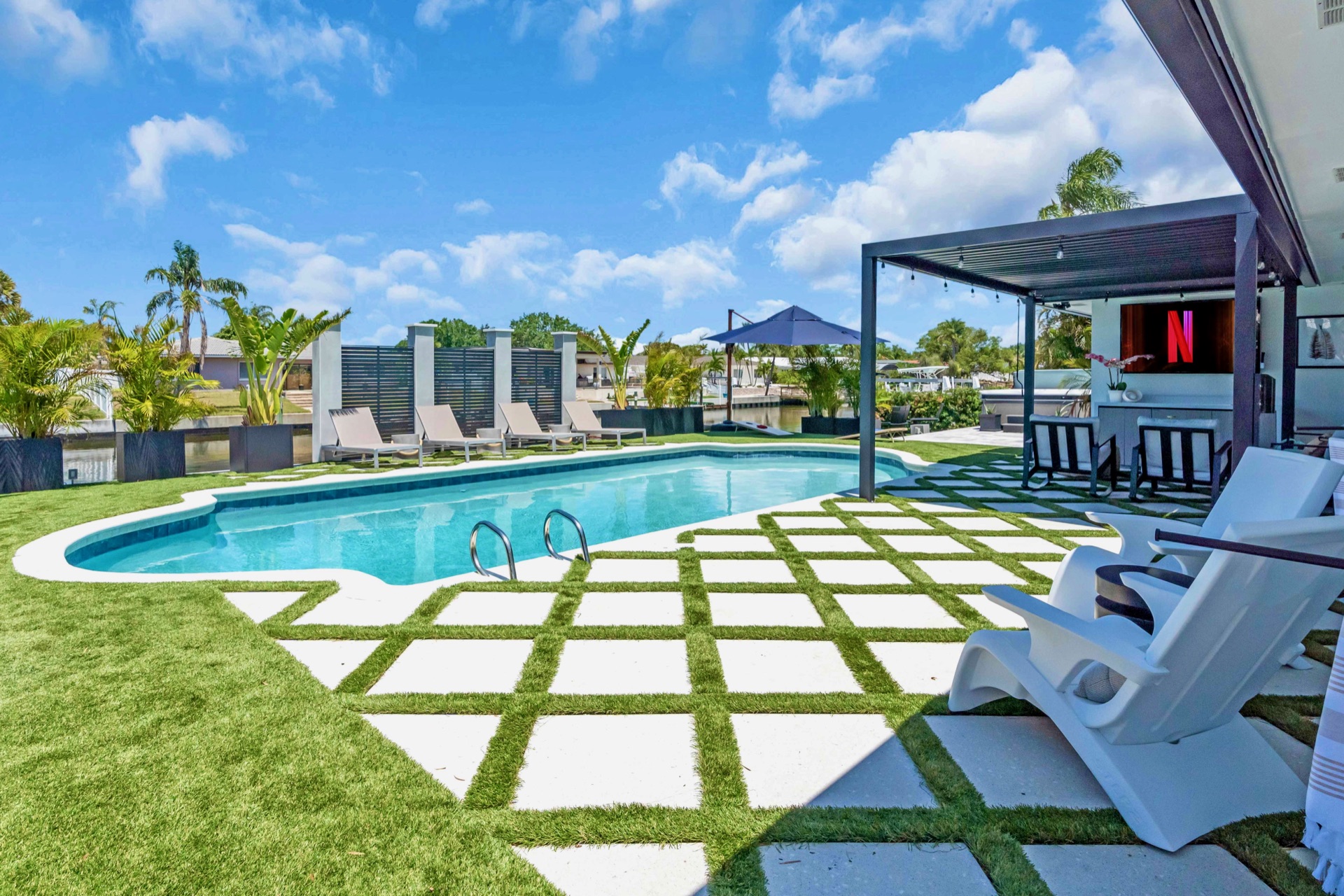 Private heated pool with cabana loungers under blue skies