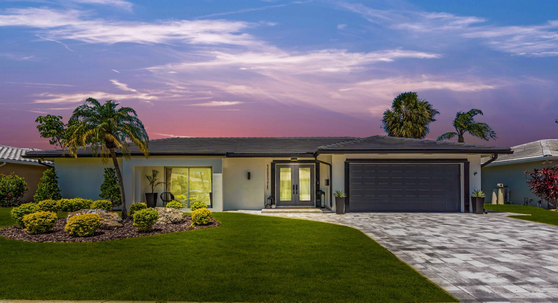 Front exterior of the luxury Tampa home under a pink sunset sky